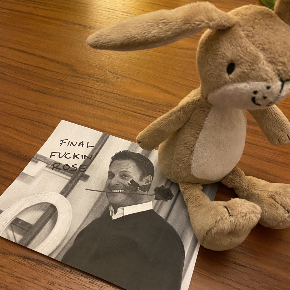 A black and white picture of Chris Harrison, with 'final fuckin rose' written in sharpie, and a stuffed bunny sitting on the paper