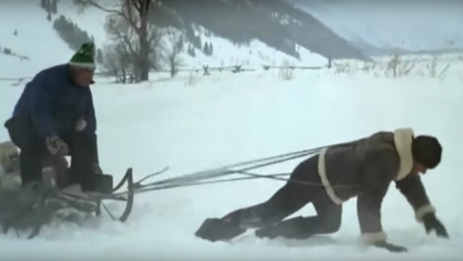 Sylvester Stallone as Rocky, pulling a sled in the snow