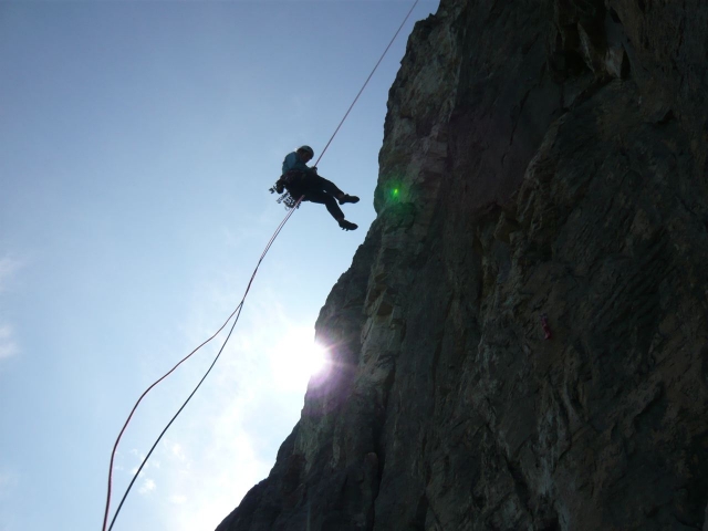 A still image of someone rappelling