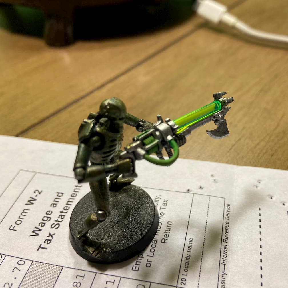 A miniature of a Warhammer 40k Necron standing on a W2 form