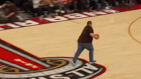 A large man comically failing to shoot a basketball